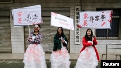 资料照- 在“国际消除暴力日”这天,三名中国女大学生打扮成家暴受害者,手举反对暴力、反对家暴的标语牌,在武汉民政局外举行抗议。