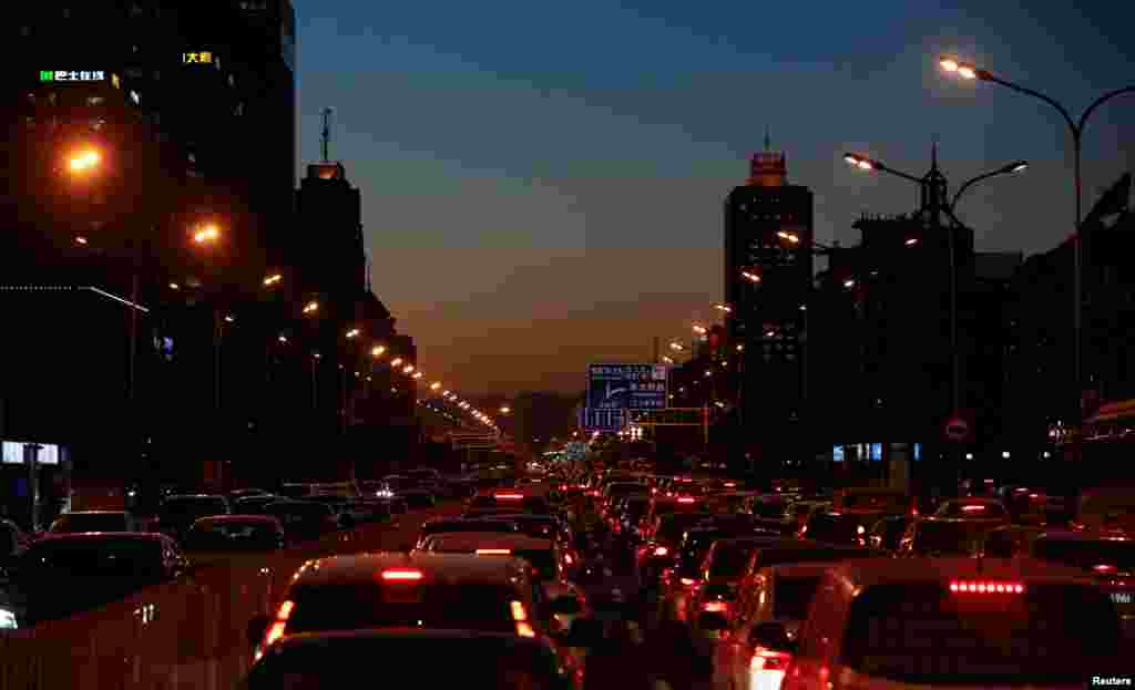 2016年12月8日夜幕初降,北京市中心的公路上塞车,汽车首尾相连。车多是北京雾霾的原因之一。塞车时的司机和乘客无法自强不“吸”
