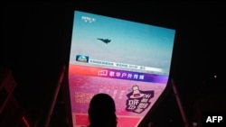 资料照片:一位男子观看中国在台湾周边进行“联合利剑”军事演习的新闻。(2024年10月14日)
