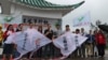 香港支联会副主席蔡耀昌(中间讲话者)及其成员5月5日冒雨举行六四风筝放飞行动 (美国之音记者申华拍摄)