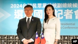2024年1月12日,星期五,台湾台北,台湾民众党总统候选人柯文哲(左)与竞选伙伴吴欣盈在国际记者会上合影。(美联社)