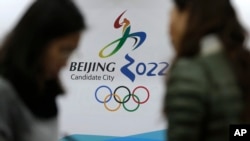 在北京申请主办2022冬奥会海报前交谈的记者们(美联社图片)