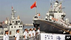 中国海军官兵登上青岛号导弹驱逐舰(右)去参加中美海军联合演习