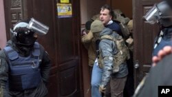 Ukrainian Security Service officers detain former Georgian president Mikheil Saakashvili at the entrance of his apartment building in Kyiv, Ukraine, Dec. 5, 2017.