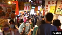 台湾台北市民众戴着口罩逛夜市。(2021年7月6日)