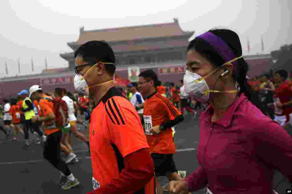 在雾霾中跑步的还有他们,2014年北京国际马拉松赛的参加者戴口罩在雾霾中跑步(2014年10月19日)