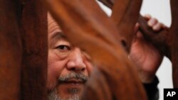 资料照:中国艺术家艾未未在伦敦艺术展览馆与他的作品在一起。(2019年10月1日)