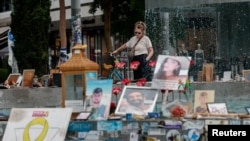 Фото: Жінка дивиться на фотографії заручників, викрадених під час смертоносної атаки ХАМАСу на Ізраїль 7 жовтня, через рік після атаки 7 жовтня 2023 року в Тель-Авіві, 7 жовтня 2024 року.