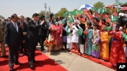 2015年4月20日巴基斯坦新闻信息部照片: 中国国家主席习近平(左前)与巴基斯坦总统侯赛因在伊斯兰堡空军基地向欢迎儿童致意