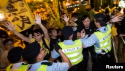 民主派活动人士在前来宣布北京特首产生方案的中国人大官员李飞下榻的酒店外与香港警察发生推搡。(2014年9月1日)