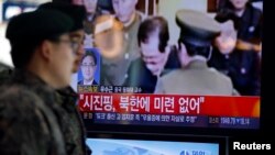 12月13日首尔火车站:韩国士兵走过电视上金正恩处决张成泽的报道镜头
