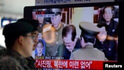 2013年12月13日在韩国首都首尔的火车站,韩国军人观看电视报道朝鲜处决张成泽的新闻。