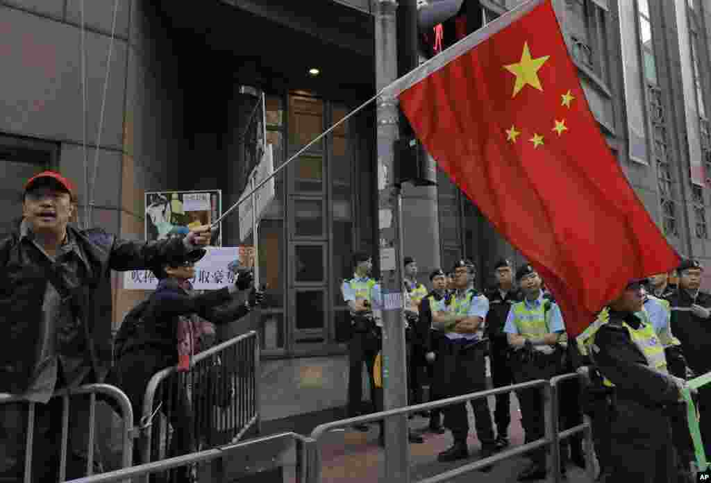 一位亲中国的香港示威者在集会中手持中国国旗(2017年1月1日)