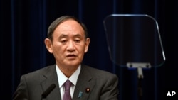 2021 年 8 月 25 日星期三,日本首相菅义伟在东京首相官邸与政府流行病咨询小组主席近江茂(未图示)一起出席新闻发布会。