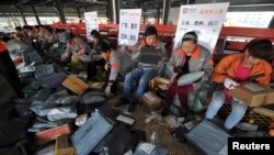“光棍节”当天,申通快递公司的工作人员在安徽省合肥市的转运站打包货物。