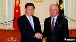 2013年10月4日吉隆坡附近纳吉办公室:中国国家主席习近平(左)和马来西亚总理纳吉布握手