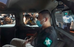 香港首位被控涉嫌违反国安法的男子唐英杰(Tong Ying-kit)坐着轮椅由警车押解至法院应讯。(2020年7月6日)
