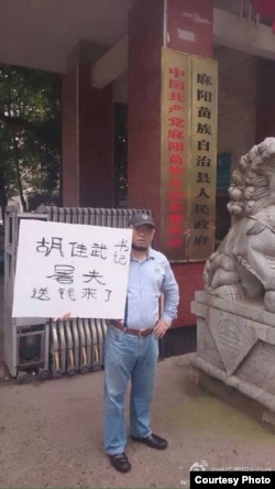吴淦在麻阳县政府门外举牌。(照片来源:新浪微博)