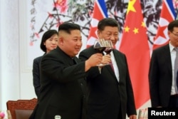 2018年6月19日,中国国家主席习近平和朝鲜领导人金正恩在欢迎宴会上举杯祝福。