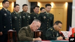 美军参联会主席邓福德上将(前左)与中国中央军委联合参谋部参谋长房峰辉在北京签署协议。 (2017年8月15日)