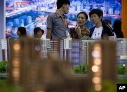 在北京的房产投资展示会上,人们看房子(2012年9月21日)