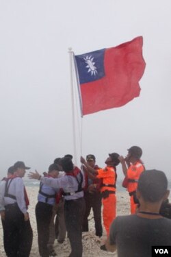 台国安会秘书长胡为真等高官视察南沙群岛,登上太平岛外的中洲礁升旗宣示主权 (台湾国安会提供图片)
