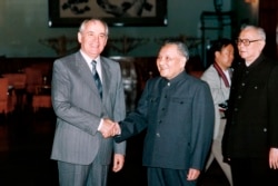 1989年5月16日中国领导人邓小平(中)与苏联共产党总书记戈尔巴乔夫(左)握手