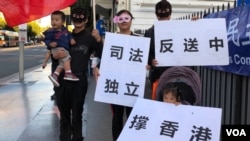 来自浙江的朱芬芬女士与丈夫(左一)和两名幼年子女一同参加星光大道的挺港行动。(美国之音雨舟拍摄)