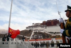 拉萨布达拉宫前面举行升旗典礼,中国武警有人持枪,有人敬礼。(2010年3月28日)