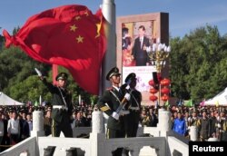 中国武警士兵在拉萨举行的西藏自治区成立50周年庆祝活动升旗仪式期间展开中国国旗。(2015年9月8日)