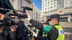 上海浦东新区法院外,一名警察阻止记者拍摄。(2021年12月28日)
