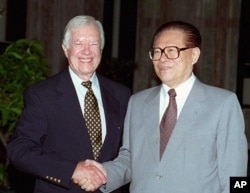 1997年7月24日,美国前总统吉米·卡特与中国国家主席江泽民在北戴河握手。