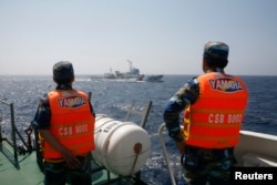 越南海岸警卫队成员在离越南海岸大约210公里处的南中国海海域观察一艘中国海警船。(2014年5月15日)
