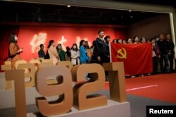 资料照:中国年轻人手举中共党旗庆祝中共建党100周年。(2021年4月22日)