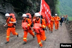2013年4月21日,在一次地震袭击四川雅安地区的第二天,救援人员快速通过瓦砾抵达被孤立的宝兴县灾区。