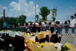 河南郑州市民在地铁5号线站台前给洪灾死难者献上鲜花,鞠躬致哀。(2021年7月27日)