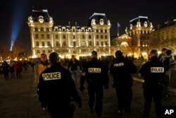 在敬拜者抵达巴黎圣母院大教堂参加圣诞夜弥撒时,法国警察在教堂附近巡逻(2016年12月24日)