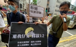 9月30日任期届满后离任的民主派立法会议员朱凯迪(右),在任期最后一日与本土派社运人士邹家成(左)陪同多名被关押盐田看守所的港人家属,到中联办外请愿,重申拒绝官派律师等4大诉求 (美国之音汤惠芸)