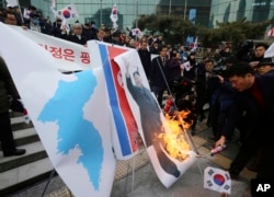 韩国民众在首尔火车站抗议朝鲜代表团来访,焚烧了印有朝鲜领导人金正恩的画像 (2018年1月22日)