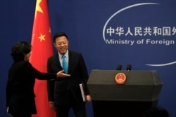 中国外交部发言人华春莹引导新任发言人赵立坚走入例行记者会会场。(2020年2月24日)