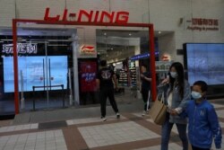人们在北京一家商场走过一家李宁运动服装品牌专卖店。(2021年4月15日)
