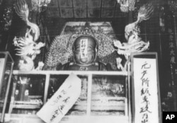在中国文革初期红卫兵破四旧运动中,寺庙饱受冲击,有佛像佛龛被贴上“打碎旧世界”“无产阶级专政”的口号(1966年8月27日)