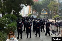 在抗议者聚集在广州恒大办公楼附近时,警察在守卫在恒大办公楼外。(2022年1月4日)