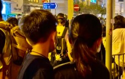 香港市民颜小姐抱着6岁的儿子8月31日晚在太子地铁站出口献花,悼念8-31事件死难者 (美国之音/汤惠芸)