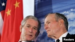 2008年8月8日,时任美国总统的小布什与前总统老布什出席美国驻华大使新馆落成典礼(路透社)