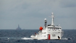 资料照:一艘中国海警船在南中国海上的一座中国海上钻井平台旁驶过。(2014年6月13日)