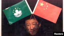 资料照:北京天安门附近一个小商贩在出售澳门和中国旗帜。