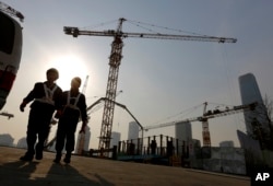 在北京的中央商业区,有工人走出建筑工地(2015年1月20日)