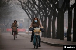 北京雾霾笼罩,行人上街带着口罩。(资料照片)