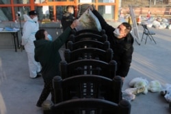 西安封城后居民食品短缺,工作人员在给居民发放蔬菜。(2021年12月29日)